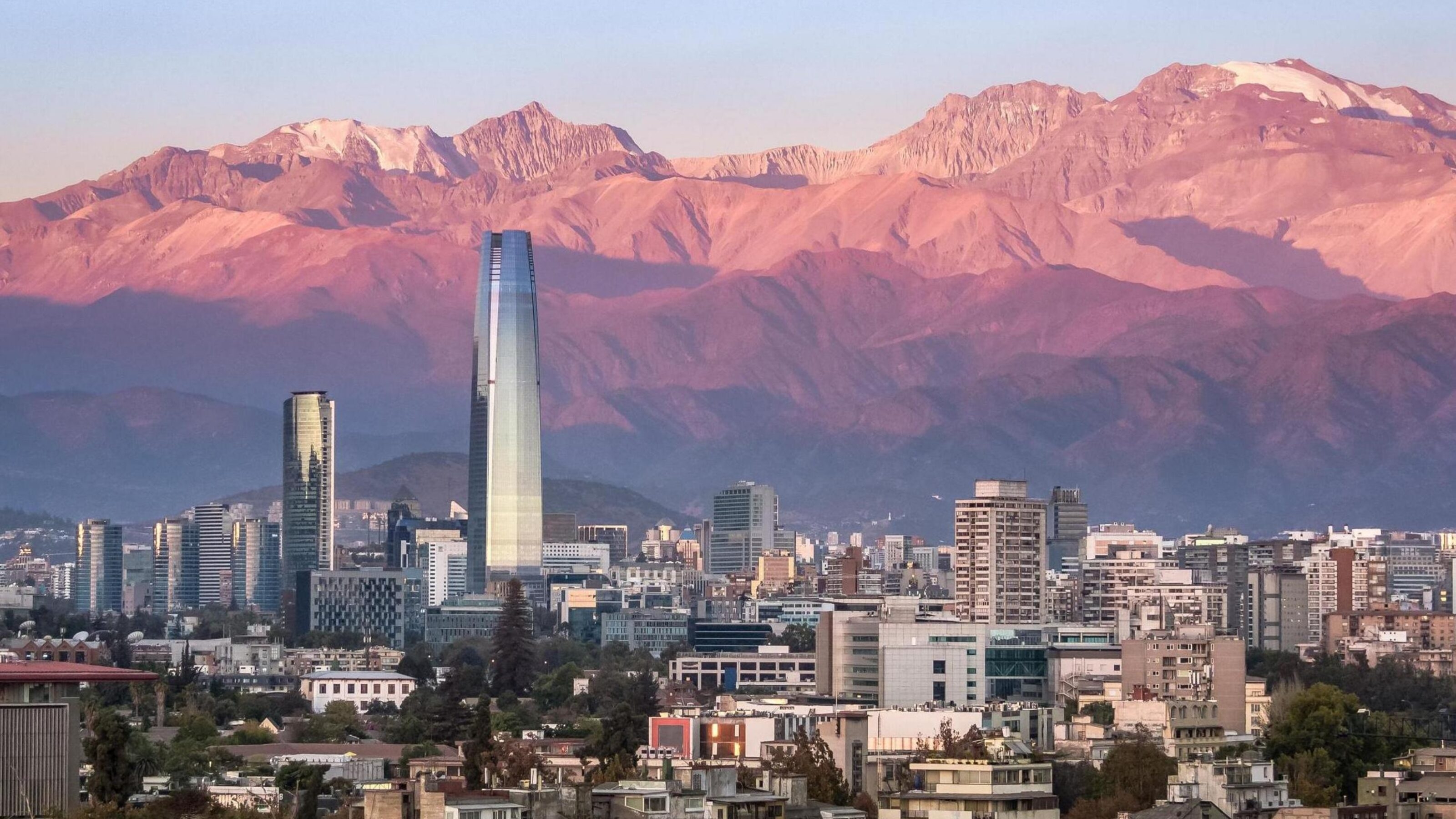 The skyline of Santiago, Chile at sunset, with mountains in the background