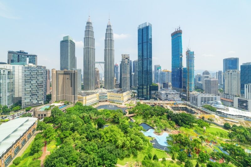 Aerial view of the KLCC Park and the Petronas Twin Towers in Kuala Lumpur, Malaysia. The urban park in Kuala Lumpur City Center is a popular tourist attraction of Asia. Awesome Kuala Lumpur skyline.