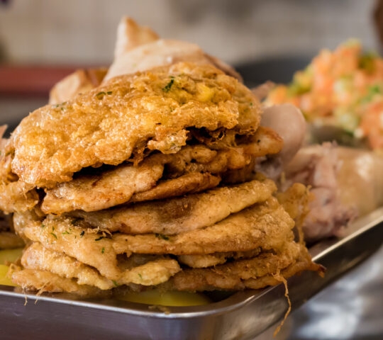 Pile of fried milanesas (milanese) in a market of Sucre, Bolivia