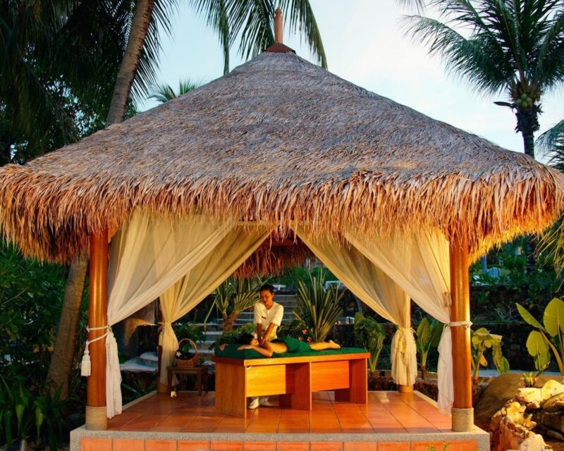 A woman gets a massage in an outdoor spa in Thailand