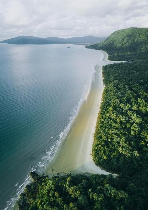 An aerial view of the Great Barrier Reef, sunset at Uluru, and the coastline of Daintree National Park