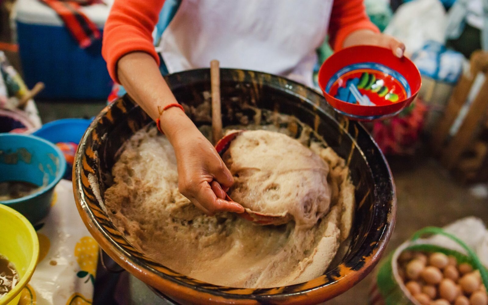A woman crafts traditional dishes at a market stall in Oaxaca