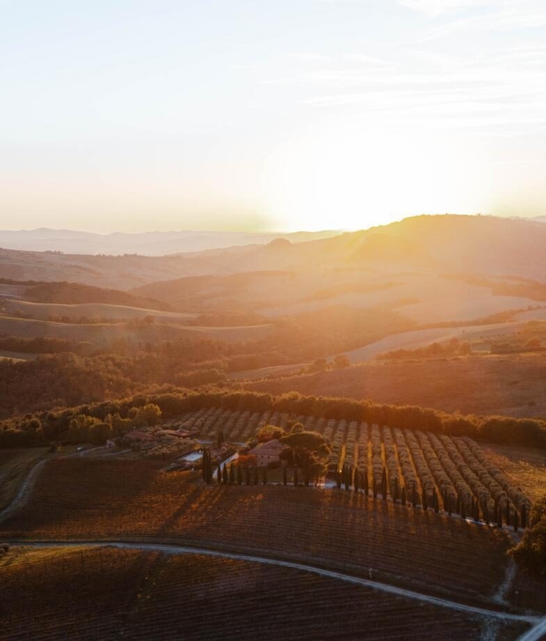 Golden light over the vineyards and rolling hills of Tuscany and a lakeside evening in Varenna with warm lights reflecting on Lake Como.
