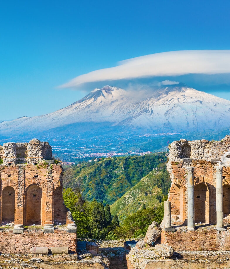 Ancient ruins overlooking Mount Etna in Sicily and turquoise waters framed by rugged cliffs along Sardinia’s coast.