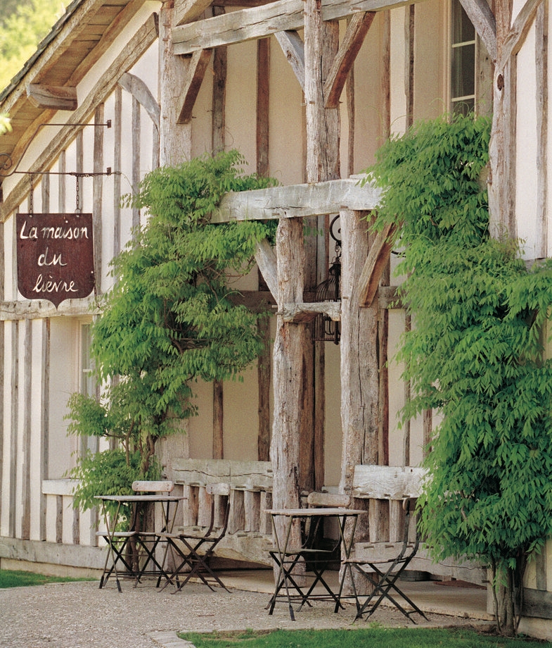 The rustic timbered façade of Les Sources de Caudalie in France, and the stone kitchen of Borgo Pignano in Italy capturing the essence of slow, organic dining.