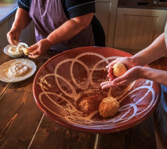 two women kneading dough during a cooking class in Greece