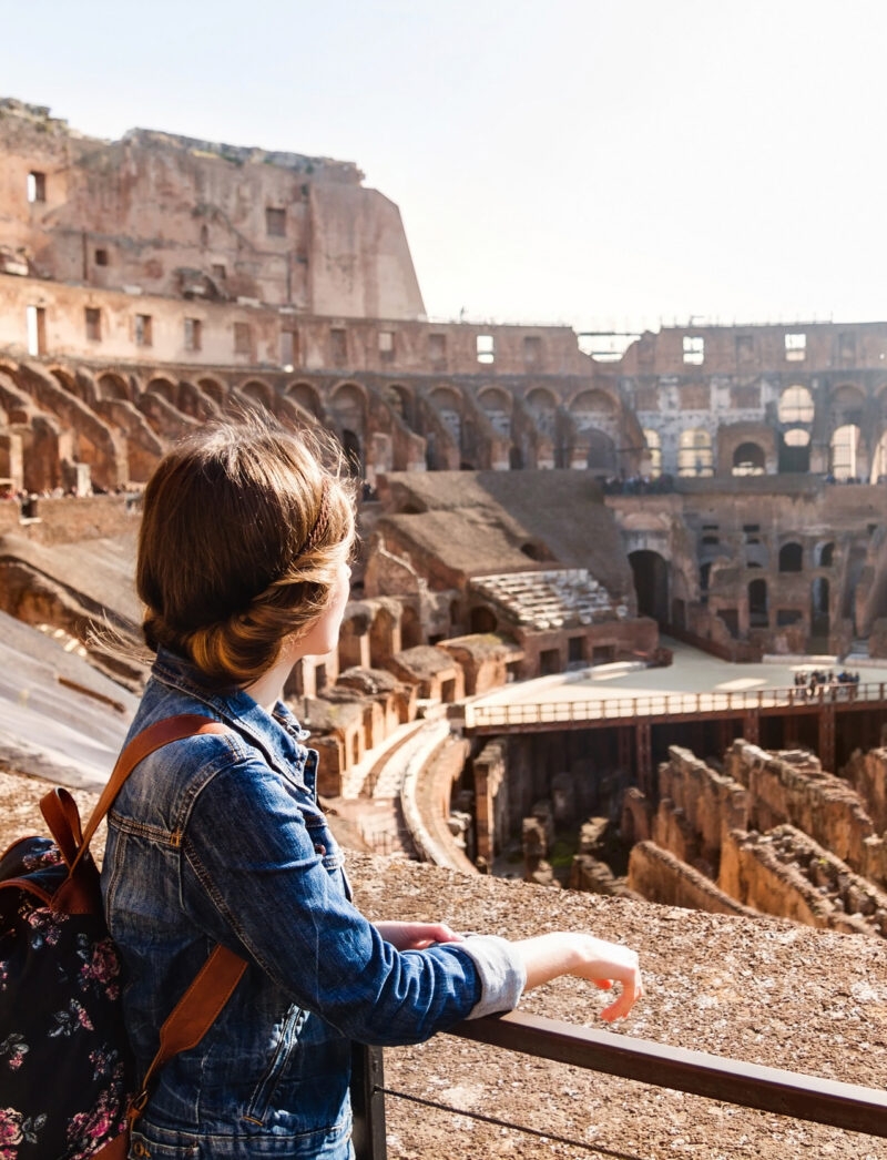 A young woman with a backpack exploring inside the Colosseum