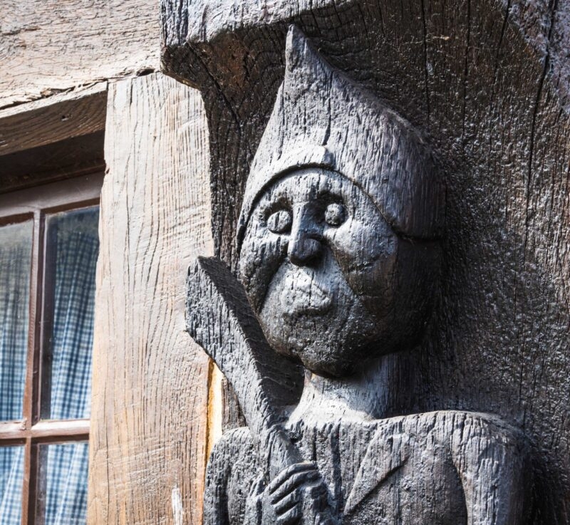 A wooden carving of a man on a building in Honfleur in Normandy.
