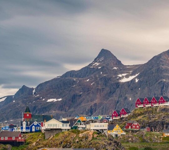 Colourful houses in the arctic village of Sisimiut in greenland with mountains in the background