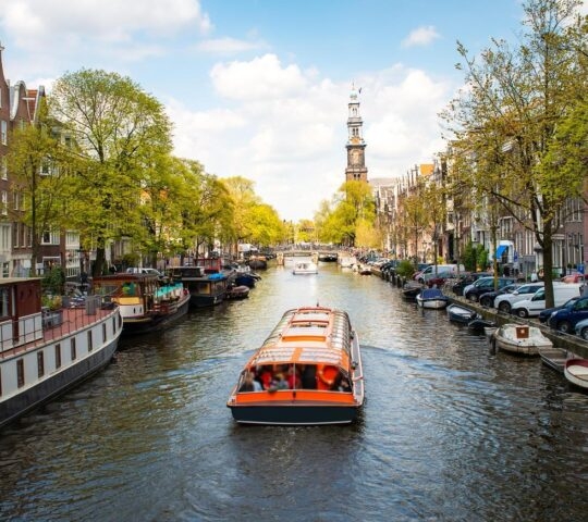 A boat cruising a canal in Amsterdam.