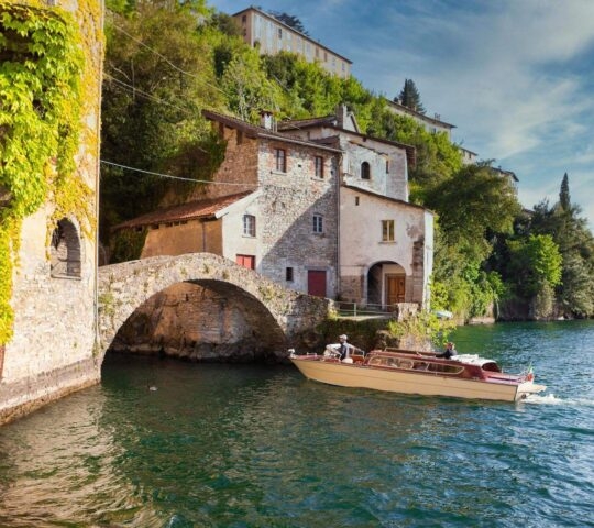 A boat about to cruise beneath the stone bridge at the end of Nesso's ravine at Lake Como.