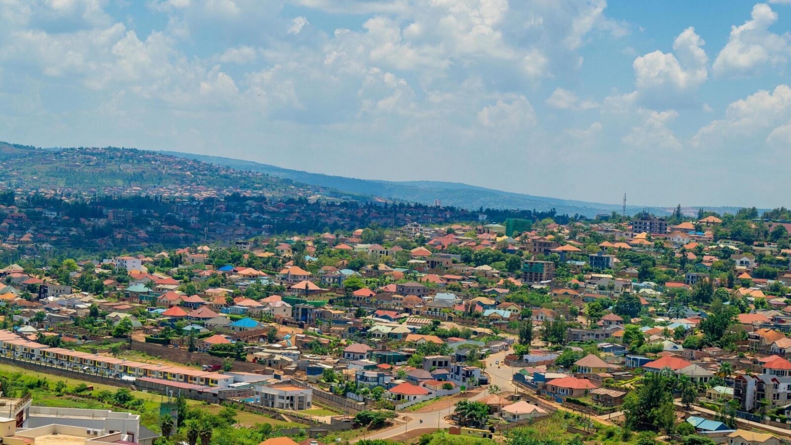 The Kigali city skyline featuring various modern skyscrapers and urban development on a sunny day.