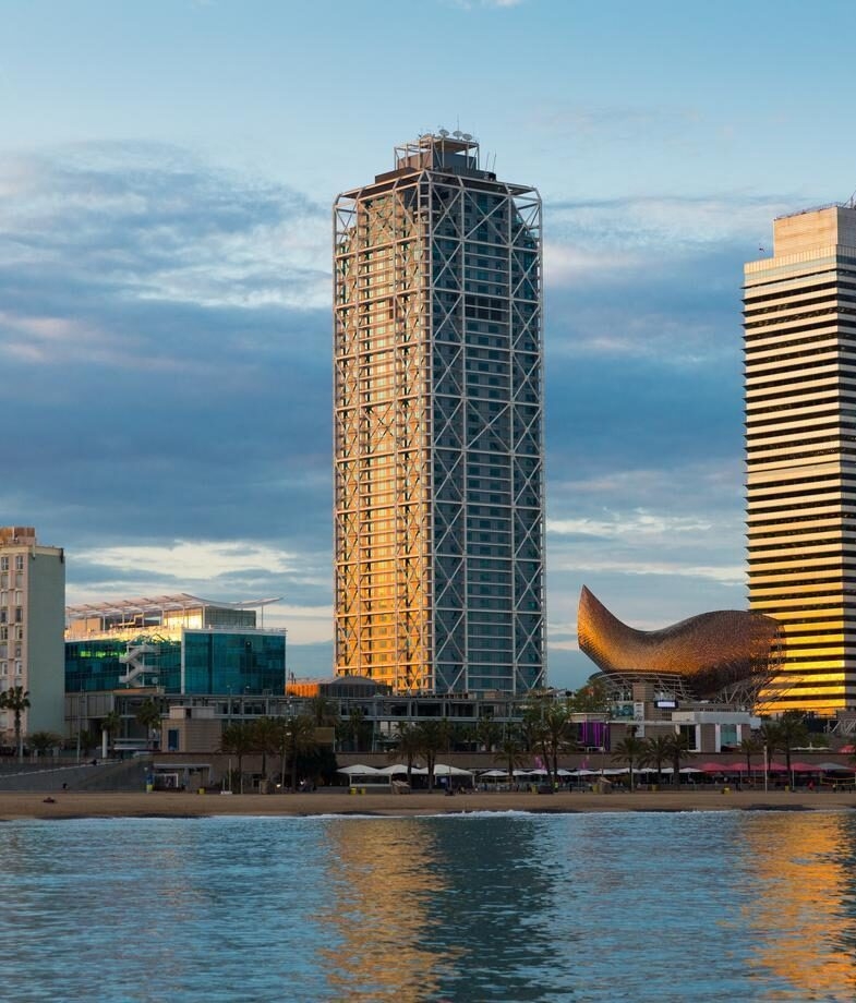 A relaxing day by the swimming pool at Belmond La Residencia, and Hotel Arts Barcelona rising above the Mediterranean beachfront at sunset.