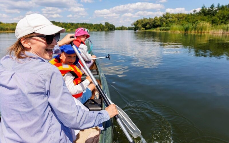 A woman and two children in a kayak on a lake
