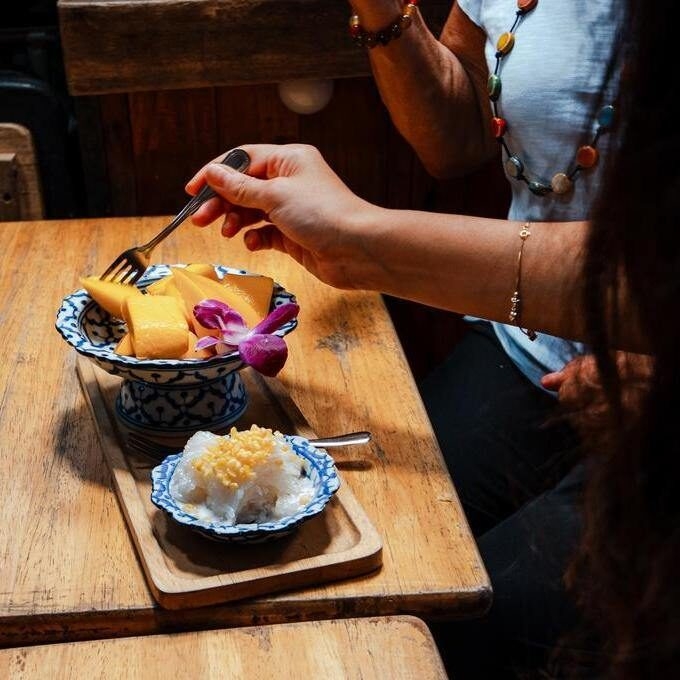 A mother and daughter enjoy mango sticky rice, a traditional Thai dessert.
