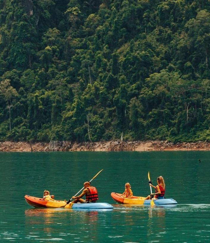 A family enjoy a kayaking activity in Cheow Lan Lake near Khao Sok National Park.