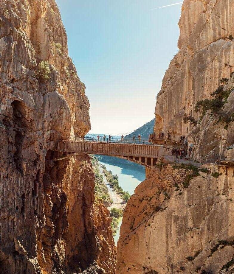 People crossing a wooden suspension bridge on Spain's Caminito del Rey hiking route