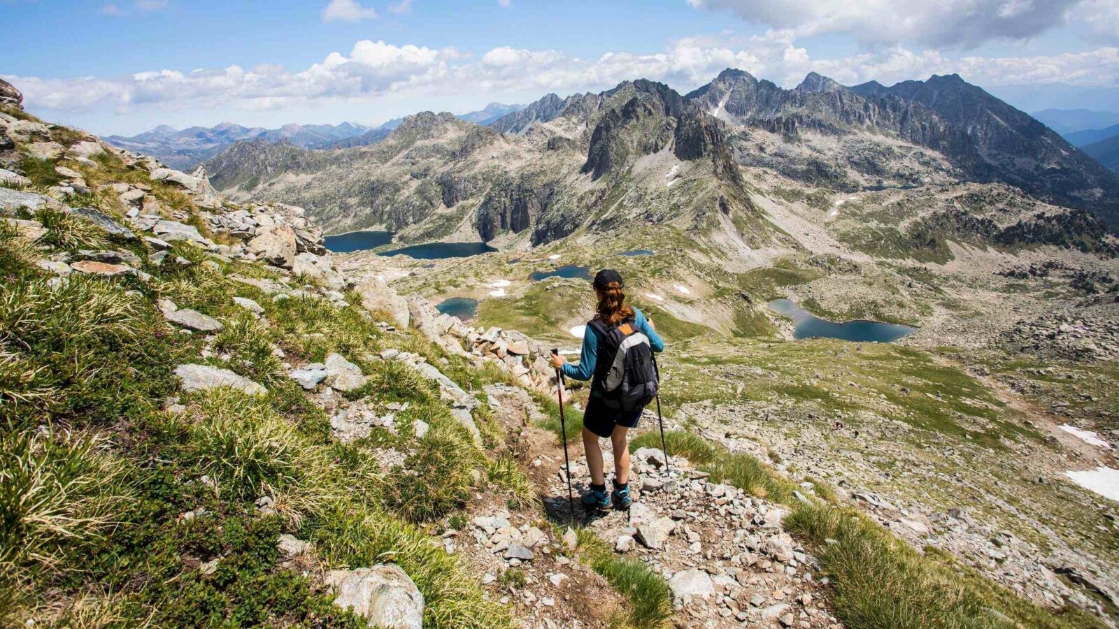 A woman hiking across mountainous landscapes in Sant Maurici National Park, Spain