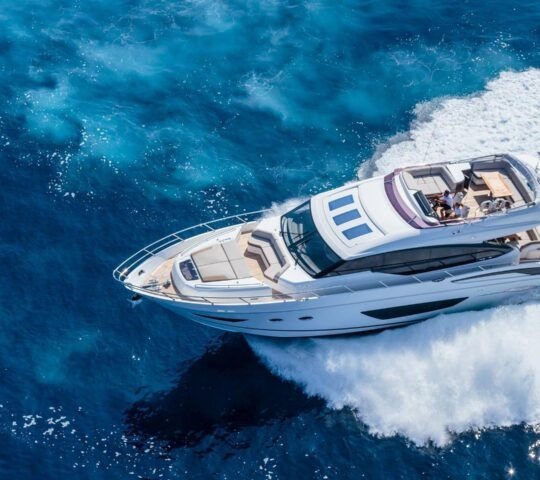Aerial view of a white boat speeding on blue water on an intimate yacht tour from Puerto Banús to Cabopino.