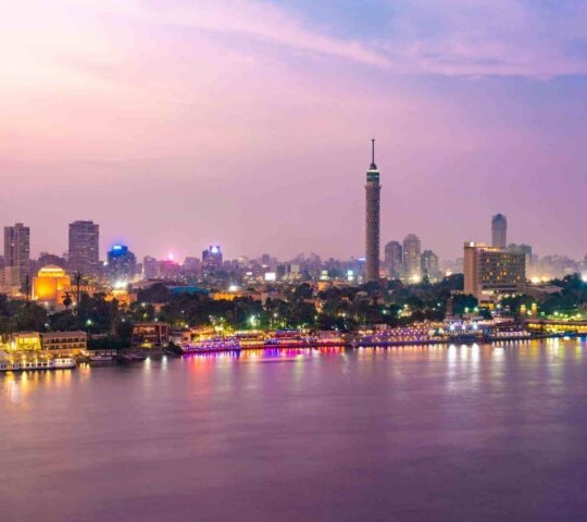 View of Cairo city centre from the river Nile lit up at sunset